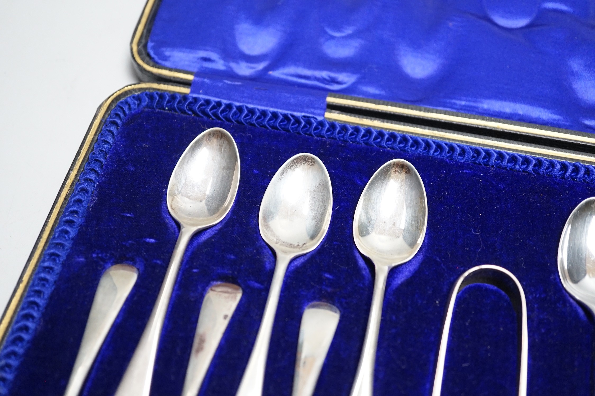 A set of twelve Edwardian silver Old English pattern teaspoons and tongs, Sheffield, 1909.